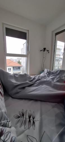 Una cama en una habitación blanca con flores en el suelo. en Blert's apartment in Gjakova, en Gjakove