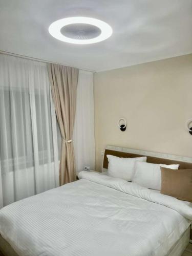 a bedroom with a large white bed with a window at Cristian's Home in Drobeta-Turnu Severin
