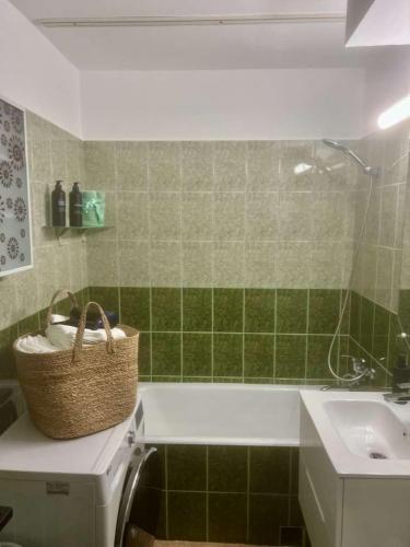 a bathroom with a basket on top of a washing machine at Cristian's Home in Drobeta-Turnu Severin