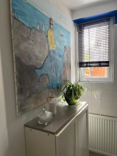 a large painting on the wall of a bathroom at La Douce Angevine in Angers