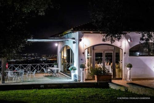 a house with a patio at night with a table and chairs at La Vista Agriturismo Boutique in Ariccia