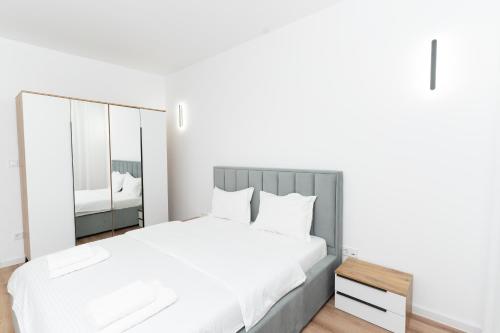 コルンカにあるMilan Luxury Apartaments XIII#Tudorの白いベッドルーム(大型ベッド1台、鏡付)