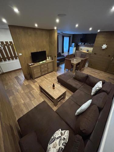 a living room with a couch and a tv at Chalupa Štikov v Podkrkonoší in Nová Paka