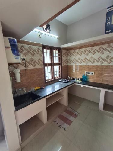 una cocina con fregadero y encimera en Saravana HomeStay, en Tiruvannāmalai