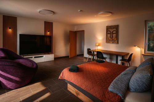 a living room with a bed and a flat screen tv at Luxury Amour Suite Modern Design mit Terrasse in Koblenz