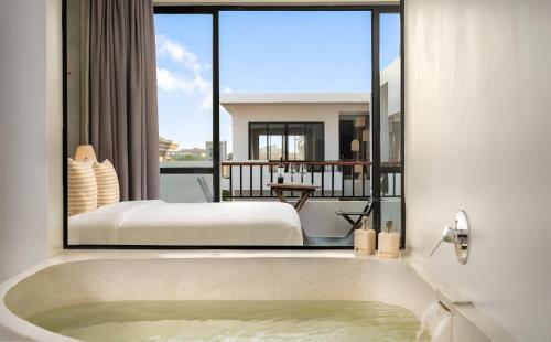 a bathroom with a tub and a bed in a room at Gold Smith Residence in Siem Reap