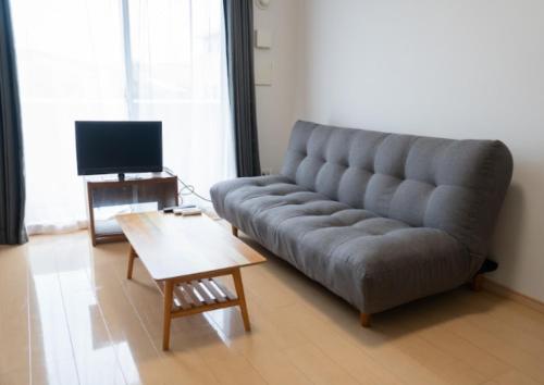 a living room with a couch and a coffee table at apartment hotel myu in Mito