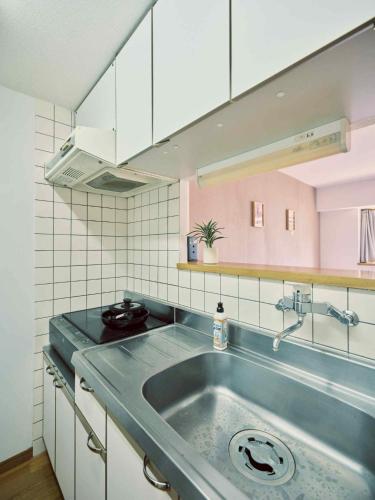 a kitchen with a stainless steel sink and white cabinets at vetta kumamoto suizenji2 204 in Kumamoto