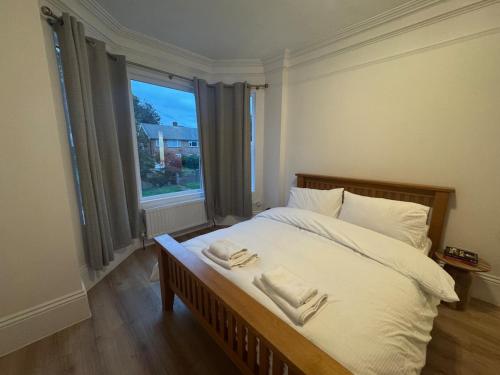 a bedroom with a bed with two towels on it at Bright & Stylish 3-Bedroom Flat in Ipswich