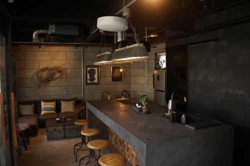 a kitchen with a counter and stools in a room at The EKAI in Toyohashi