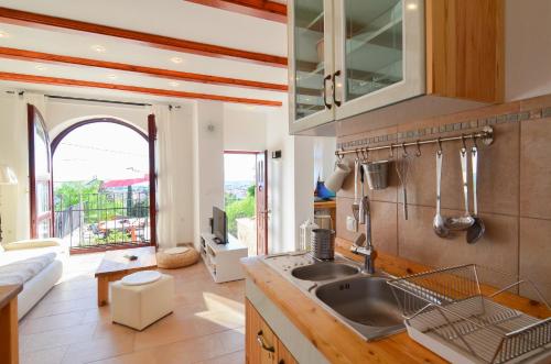 a kitchen with a sink and a living room at Eler Home in Zadar