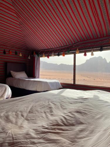 two beds in a room with a red roof at Golden Camp Tours in Wadi Rum