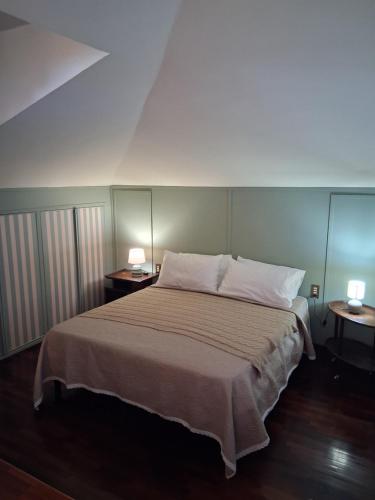 a bedroom with a bed with two lamps on two tables at Alina Villa with shared pool in Montecatini Terme