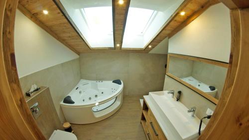 a bathroom with a large tub and a sink at Chalets Frauenalpe in Sankt Lorenzen ob Murau