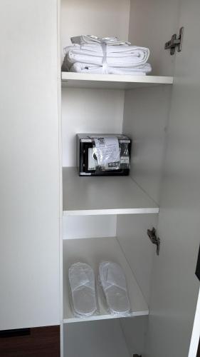 a white cupboard with a toaster and some towels at Peaceful Cozy 1 BHK Pool Garden View Liwan Dubai Land in Dubai