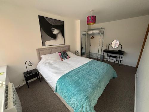 a bedroom with a bed and a painting on the wall at New City Centre Apartment No 5 Free Parking in Leicester