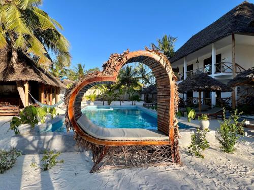 an arch shaped pool at a resort on the beach at Pamoja Villas in Migogoni
