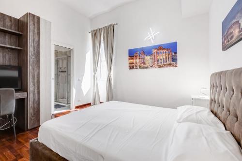 a white bedroom with a bed and a television at StarHome Colosseo in Rome