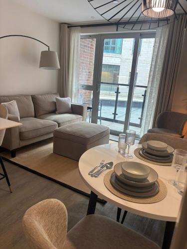 a living room with a couch and a table with plates on it at Entire Prestige Apartment in Poole Quay - Free Parking, Fast WiFi, Smart TV & Netflix in Poole