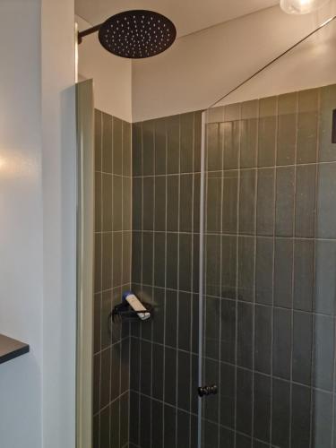 a bathroom with a shower with a glass door at Lumi, modernes Attika-Refugium in Derendingen