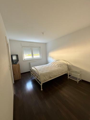 a bedroom with a bed and a television in it at Bartappart in Bartenheim