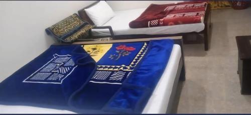a room with two beds and a blue blanket at Grand Arham Hotel Faizabad in Rawalpindi