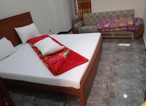 a bedroom with a bed with a red blanket on it at Grand Arham Hotel Faizabad in Rawalpindi