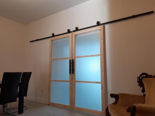 een glazen schuifdeur in een kamer met een stoel bij U Mariki 