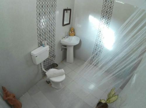 une salle de bain blanche avec toilettes et lavabo dans l'établissement Classic Villa - Near Jaisalmer Fort, à Jaisalmer