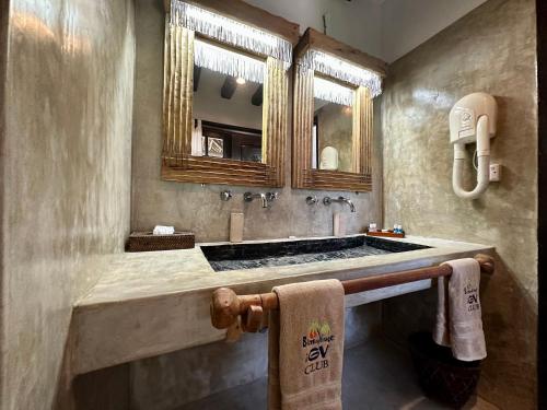 a bathroom with a sink and a mirror at Blue Bay Village in Watamu
