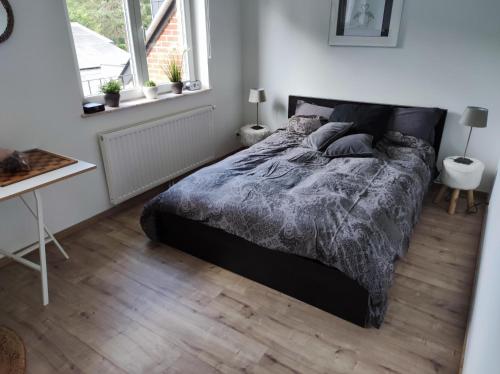 a bedroom with a bed and a desk and windows at Maison indépendante proche de Liège -Séjour nature & confort in La Salle