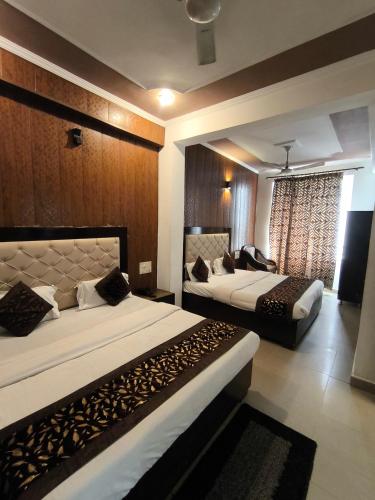 En eller flere senge i et værelse på Hotel Aashray