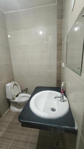 a bathroom with a sink and a toilet at Hotel Aashray in Haridwār