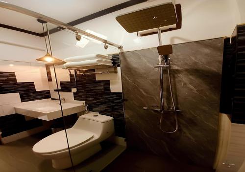 a bathroom with a toilet and a shower and a sink at Intimate Riverside Resort Vang Vieng in Vang Vieng