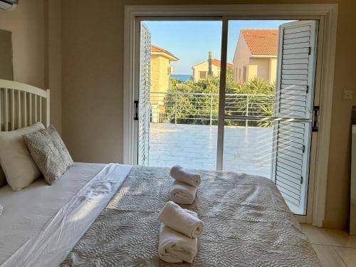 a bedroom with a bed with two towels on it at Onyx Beach Villa - Cozy 2BR - Walk to Beach in Meneou