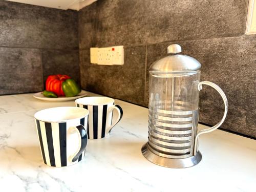 a blender sitting on top of a counter with two cups at Onyx Beach Villa - Cozy 2BR - Walk to Beach in Meneou