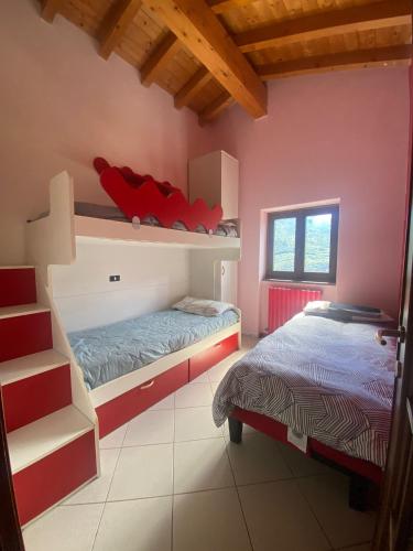 two beds in a room with pink walls at casa vacanze LA CA Del Cunfec in Sondrio