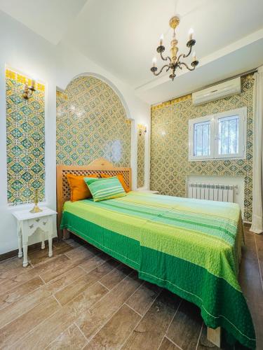 ein Schlafzimmer mit einem Bett und einem Kronleuchter in der Unterkunft La Maison de haut in Tunis