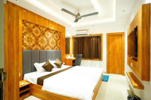 a bedroom with a bed and a ceiling fan at JRF Hotel in kolkata