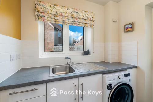 una cocina con fregadero y lavadora en Pass the Keys Spacious Modern Family Home - 20 mins to Oxford, en Garford