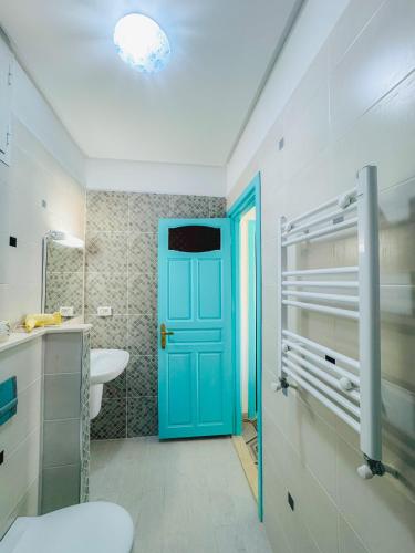 a bathroom with a blue door and a sink at La Maison de haut in Tunis