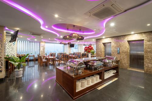 a restaurant with purple lights on the ceiling at GOLDEN SUN DANANG Hotel in Da Nang