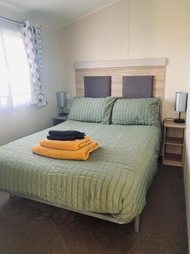 a bedroom with a bed with an orange towel on it at Paul’s place silversands in Lossiemouth