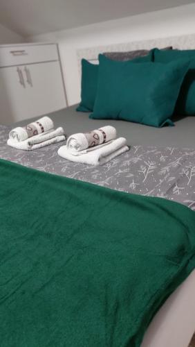 two towels on a bed with a green blanket at Stan na dan Zvornik in Zvornik