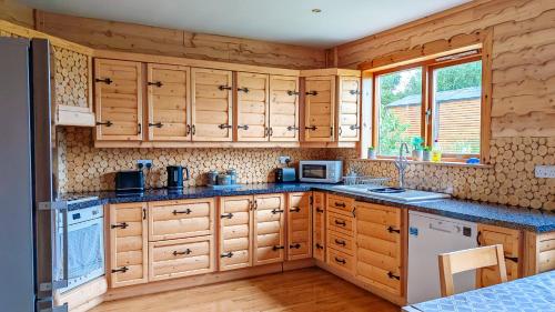 a kitchen with wooden cabinets and a sink at Fern Lodge. Drumcoura Lake Resort, in Ballinamore