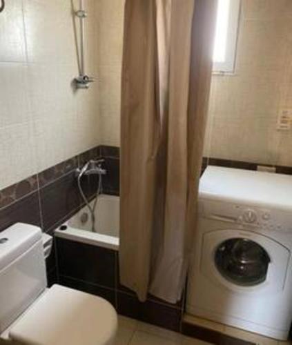 a bathroom with a toilet and a washing machine at 98. Homey 2BR Townhouse 2 Queen Beds Garden in Sheikh Zayed