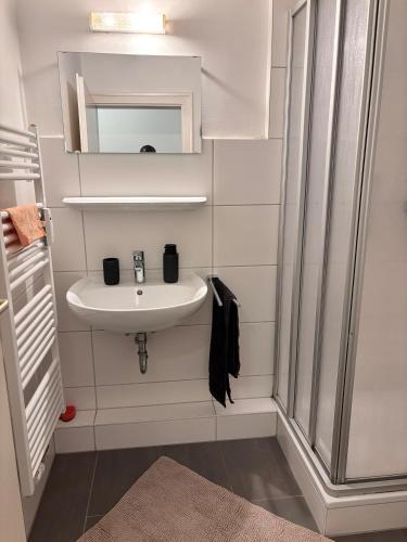 a white bathroom with a sink and a mirror at Charming apartment with a view in Wolfsburg