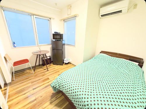 a bedroom with a bed in a room with windows at Small stay in Tokyo in Tokyo