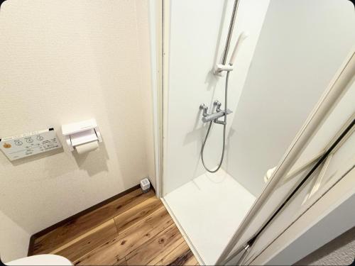 a shower stall in a bathroom with a wooden floor at Small stay in Tokyo in Tokyo