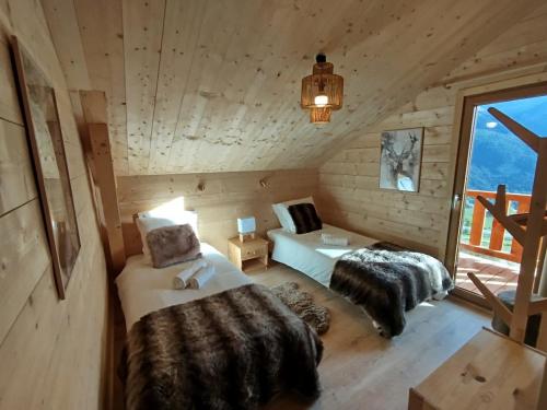 a bedroom with two beds in a log cabin at Chalet des Aigles Reallon in Réallon